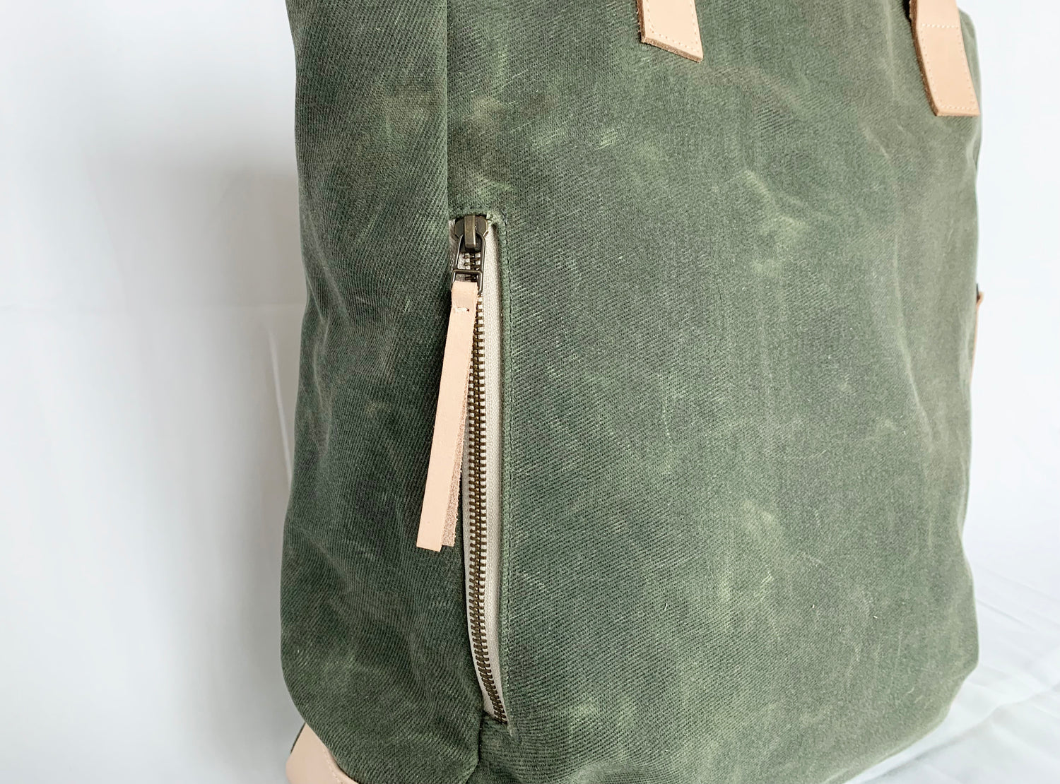 The Wild One, the olive tote, with a view of the clean lined exterior zipper pocket. 